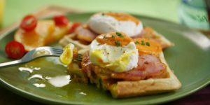 Eggs Benedict with Peameal Bacon on Scallion Waffles with Tomato Cream